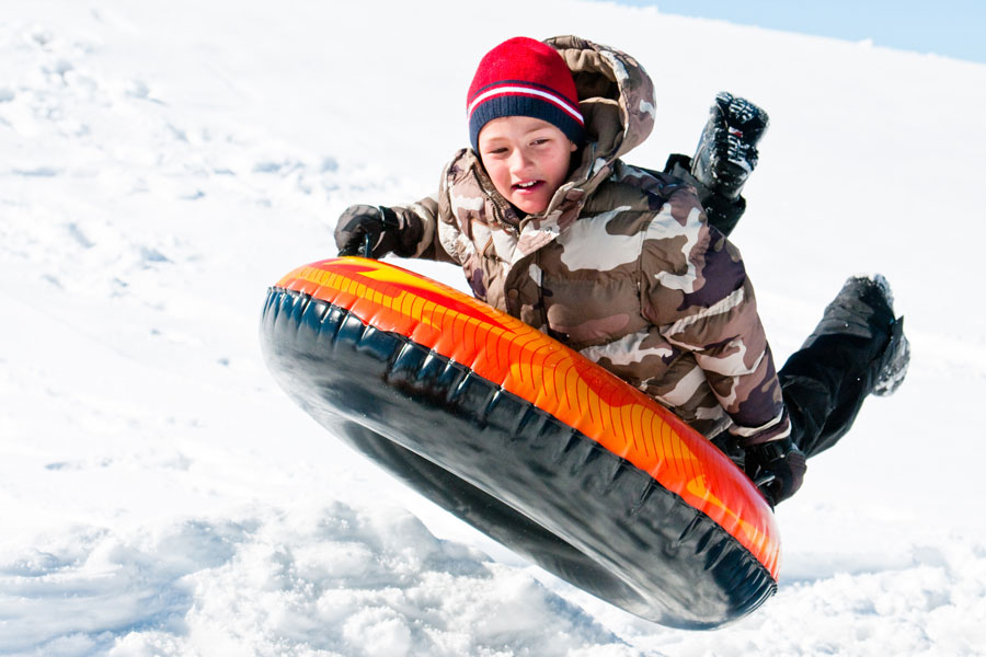 boy riding snow tube